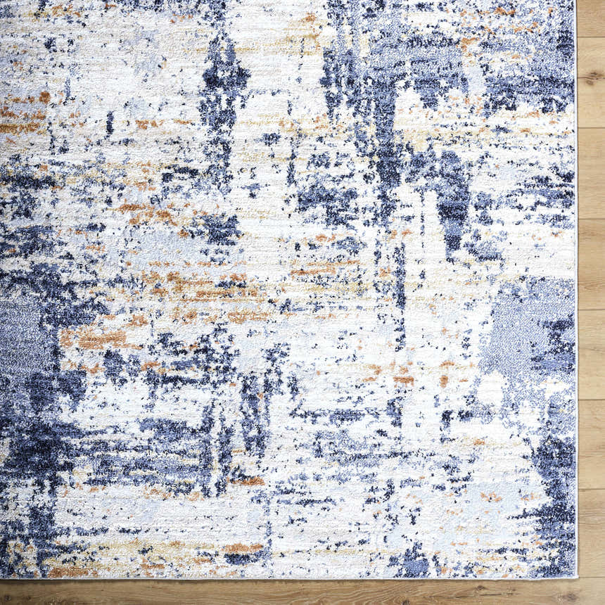 Close-up of the Bazyli Area Rug. Contemporary style with ivory, light gray, navy, peach, and white abstract pattern. Corner