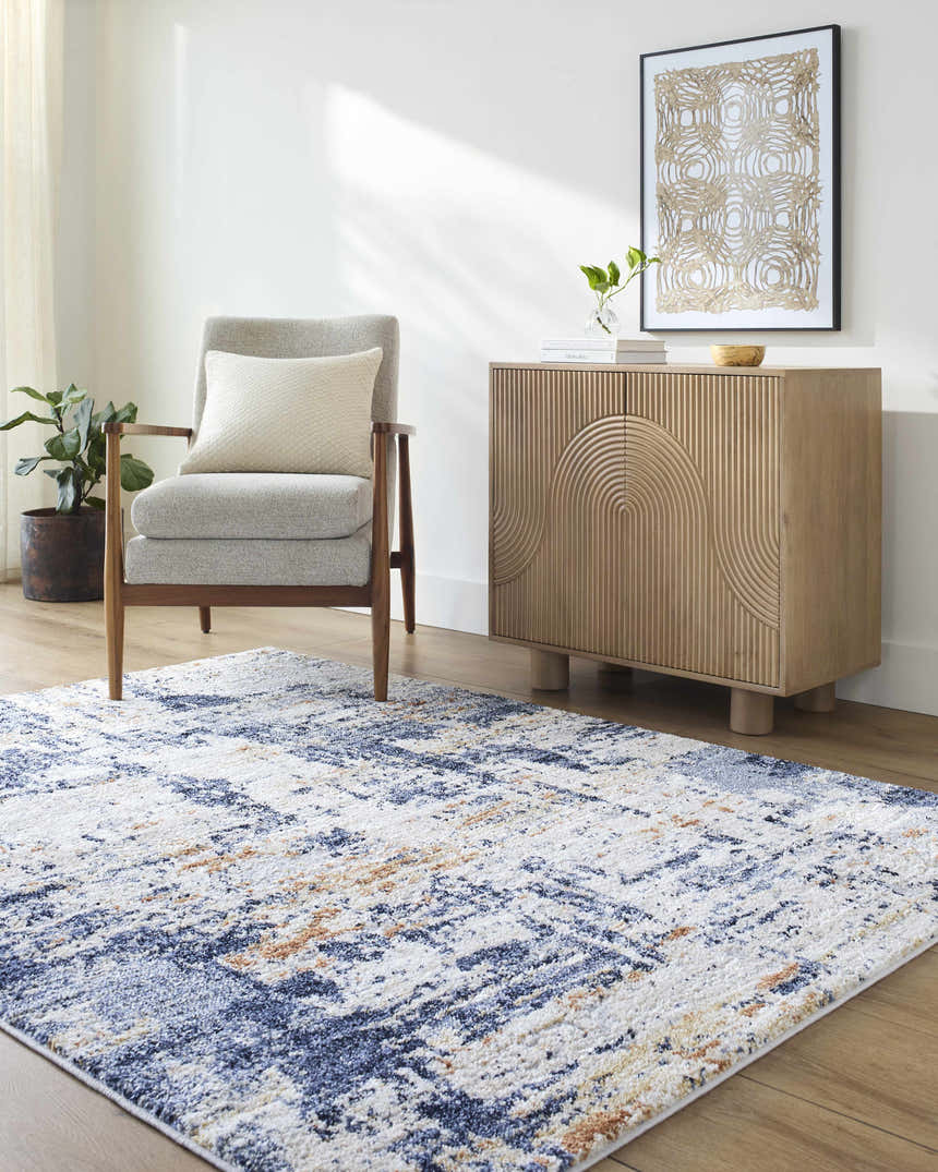 Living room scene with a Bazyli Area Rug in ivory, light gray, navy, and peach. Roomscene-Rectangle