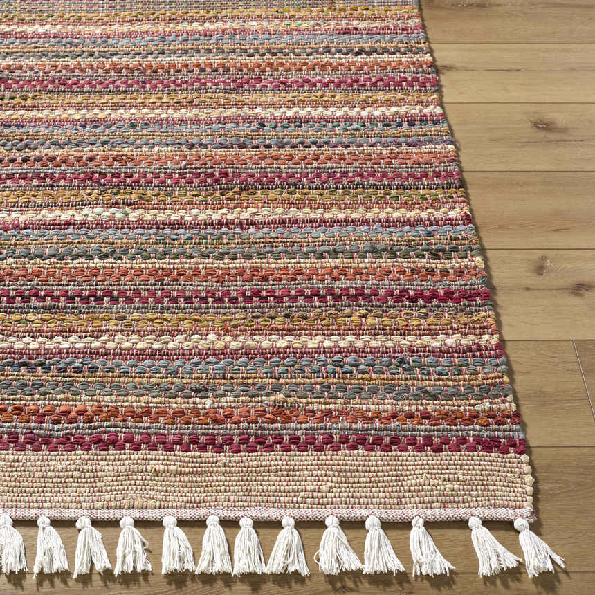 Close-up of the hand woven Brenda Crimson Area Rug. Features colorful horizontal stripes and white tassels. Front