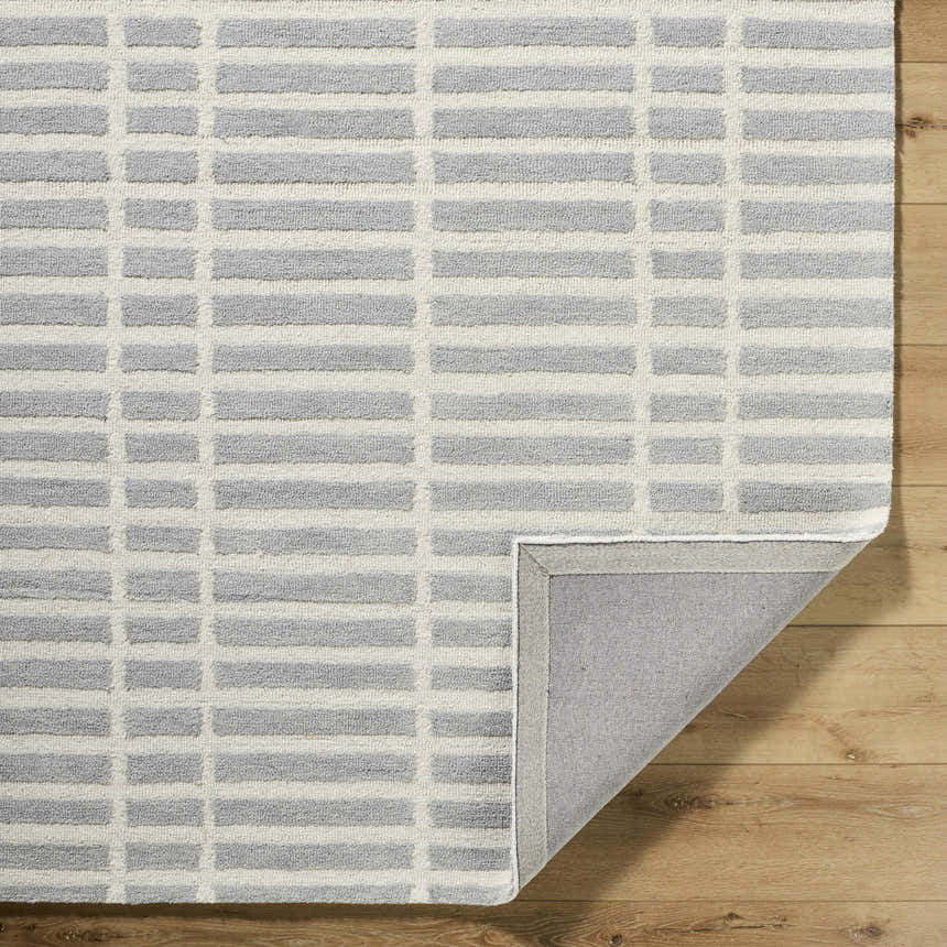 Close-up of the Bendek Medium Gray Area Rug. Ivory and gray geometric pattern on a hand-tufted wool rug. Fold