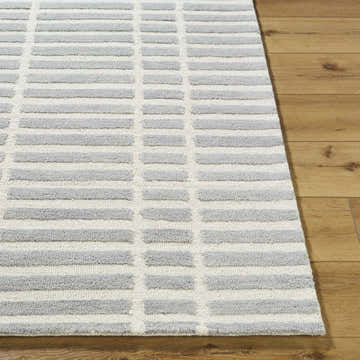 Close up of the Bendek Medium Gray Area Rug showing its ivory and gray geometric design and wool texture. Front