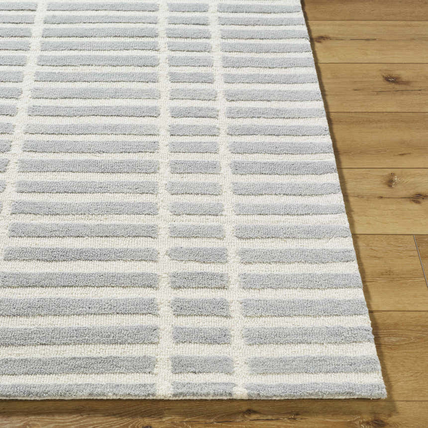 Close up of the Bendek Medium Gray Area Rug showing its ivory and gray geometric design and wool texture. Front
