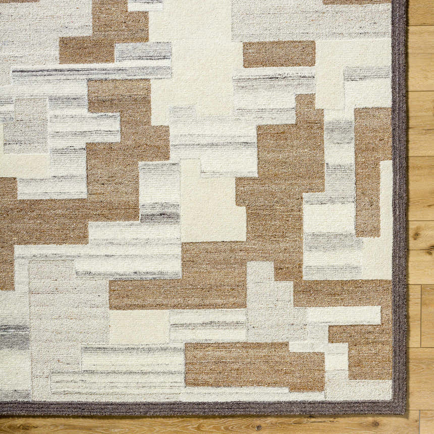 Close-up of the Berker Area Rug showcasing a contemporary geometric pattern in beige, cream, taupe, and charcoal. Hand-tufted wool texture. Corner