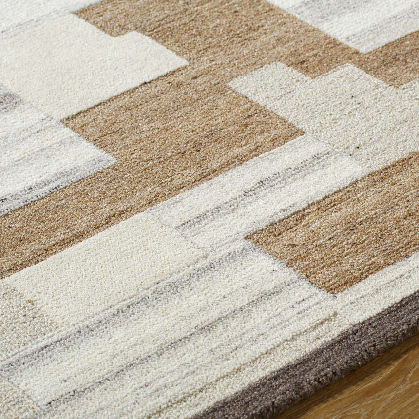 Close-up of the hand-tufted Berker Area Rug. Beige, cream, charcoal, and taupe wool form a contemporary geometric pattern. Texture