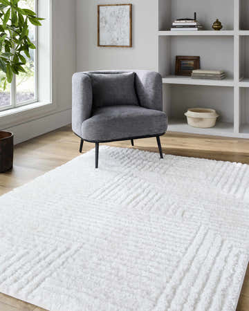 Living room scene with gray chair and white Bulana Area Rug. Roomscene-Rectangle
