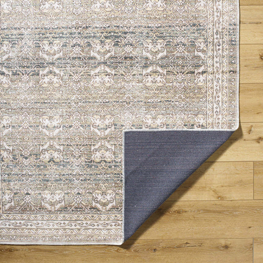 Close-up of Billie Vintage Flat Pile Washable Rug. Cream, green, and peach traditional pattern on a polyester rug. Fold