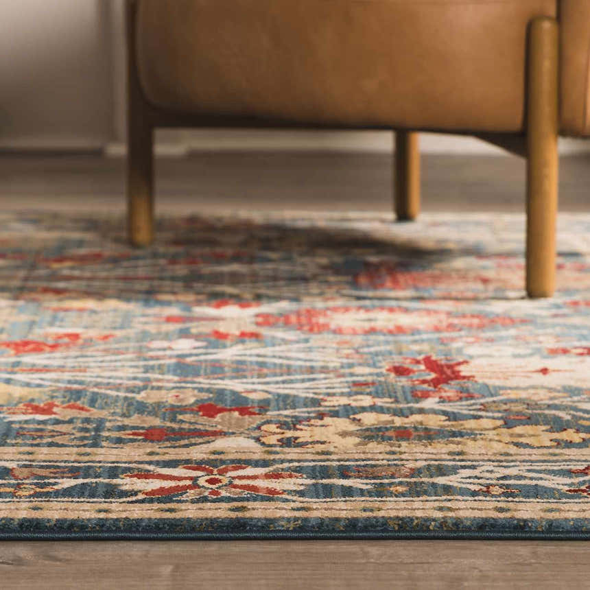 Close-up of the Neola Navy Blue Damask Area Rug showing its red, tan, and blue bohemian pattern and texture. Roomscene-Rectangle