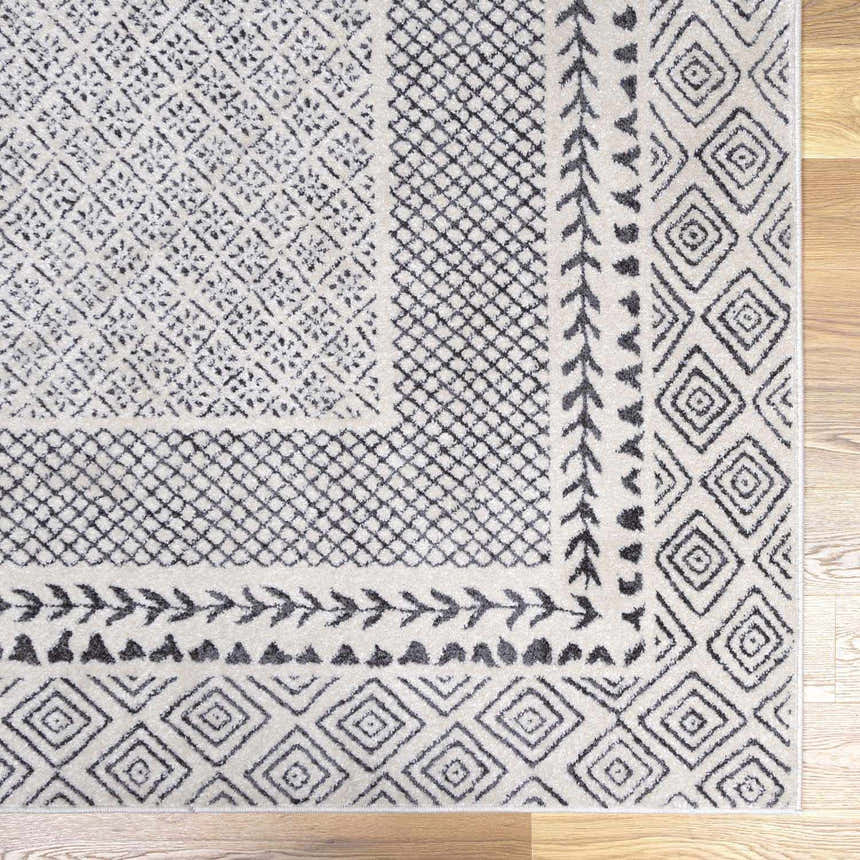 Close-up of the Burdette Soft Neutral Rug, showcasing its charcoal, gray, and light beige geometric pattern. Swatch