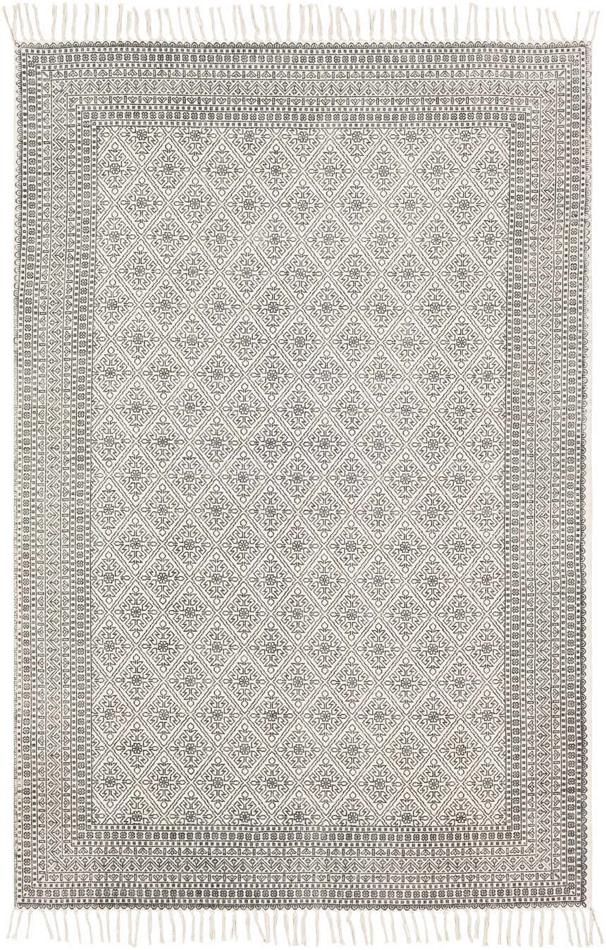 Close-up of the Brushton Area Rug. Hand-woven cotton rug in beige and black with a diamond and floral pattern and fringed edges. Design-Rectangle-576