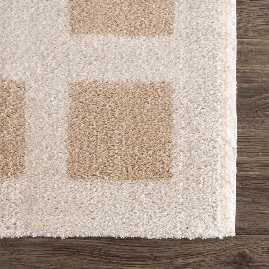 Close up of the plush Beynon Beige Washable Area Rug with a geometric square pattern in beige and peach tones. Swatch