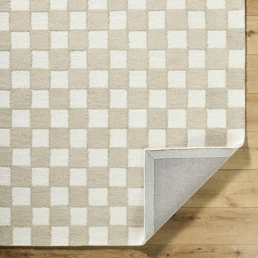 Close up of the Amparo Beige Area Rug showing a beige and ivory checkerboard pattern and hand tufted wool texture. Fold