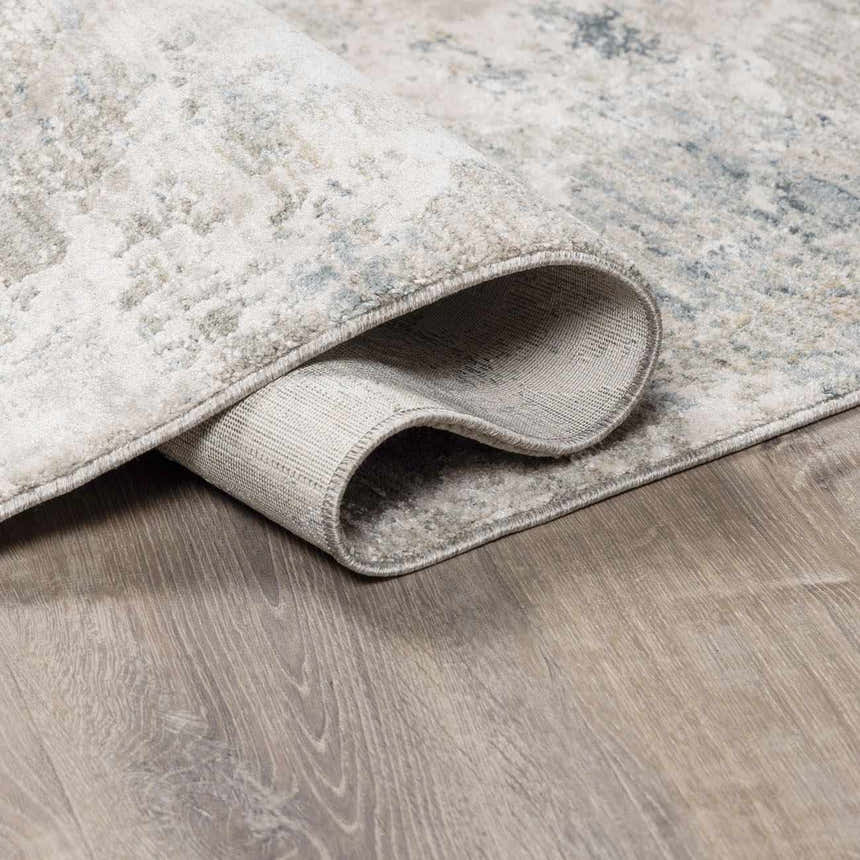 Close-up of the Burstwick Thick Luxe Boutique Rug showing its dusty sage, navy, and taupe abstract pattern and texture. Fold
