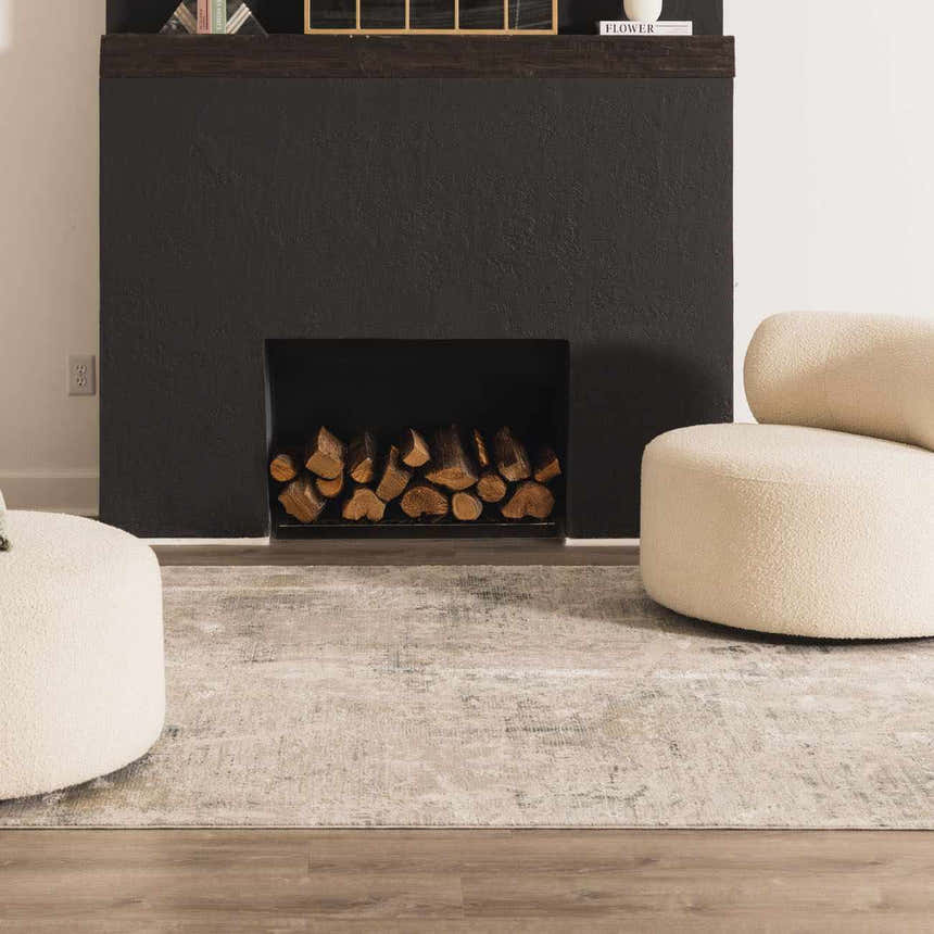 Living room scene with a Burstwick Thick Luxe Boutique Rug, fireplace, and cream-colored chairs. Roomscene-Rectangle