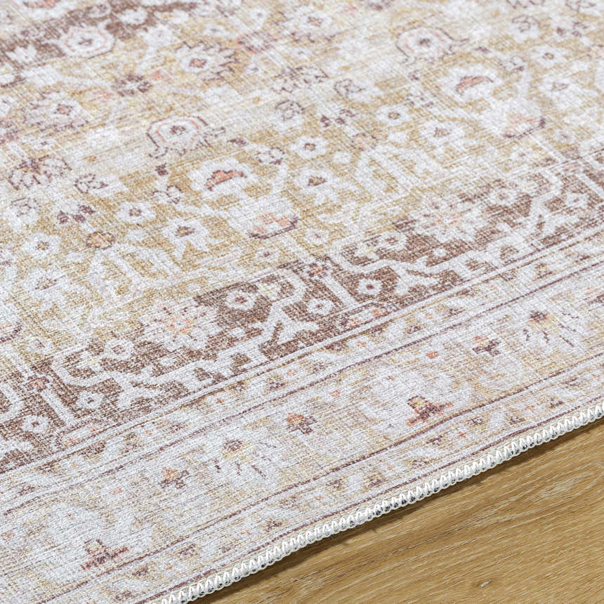 Close-up of Bienna Vintage Flat Pile Washable Rug showing camel, cream, brown, and peach traditional farmhouse pattern. Texture