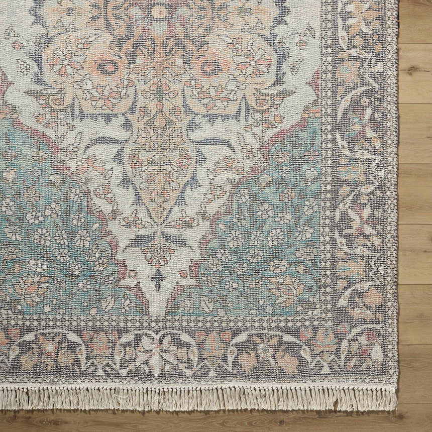 Close-up of the hand-loomed Bohdan Teal Area Rug. Features traditional floral patterns in teal, peach, ivory, and pink. Corner