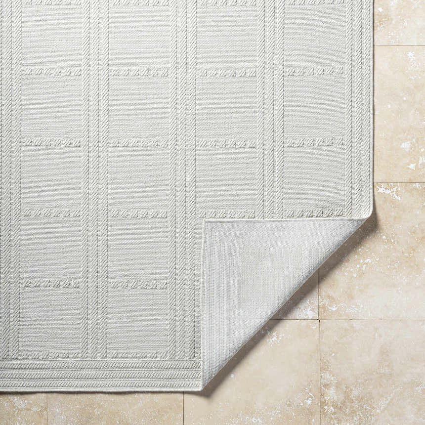 Close-up of the light silver Bahari Area Rug showing a geometric pattern and woven texture. Fold