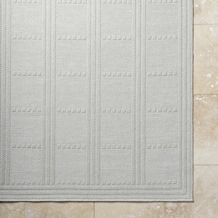 Close-up of the light silver Bahari Area Rug, showcasing its woven texture and geometric pattern. Corner