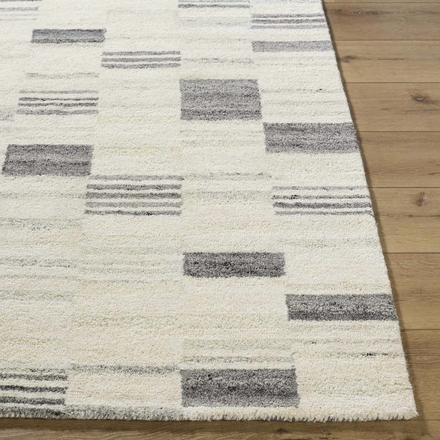 Close-up of Max Handmade Becki Owens x LIVABLISS BOMX-2305 Area Rug. Cream wool rug with ash and charcoal geometric pattern. Front