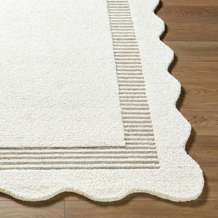 Close-up of the Tono Ivory Border Hand Tufted Wool Area Rug showing the wool texture, striped border, and scalloped edge. Front