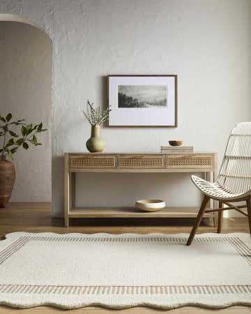 Entryway scene with a Tono Ivory Border Hand Tufted Wool Area Rug, console table, white chair, and neutral decor. Roomscene-Rectangle