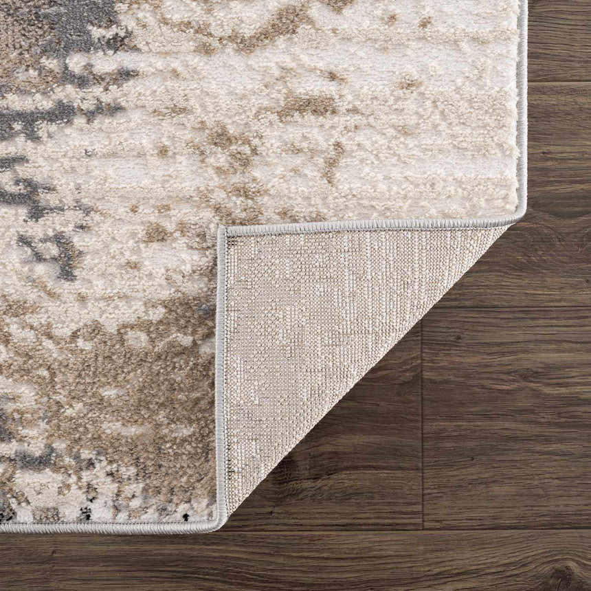 Close-up of the Birdie Area Rug showing ash, silver gray, and sage tones. Machine woven texture and backing detail. Fold
