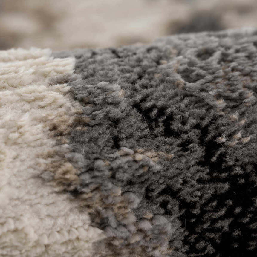Close-up of the plush texture and ash, silver gray hues of the machine-woven Birdie Area Rug. Fold
