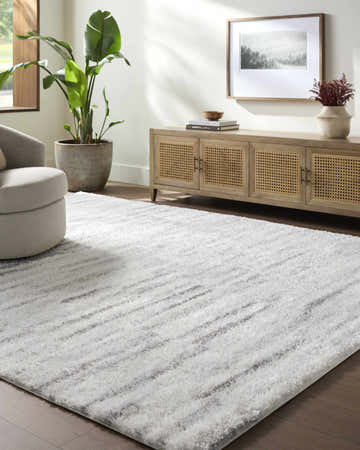 Living room with a gray swivel chair and the Benjen Gray Area Rug. Neutral tones and natural light. Roomscene-Rectangle