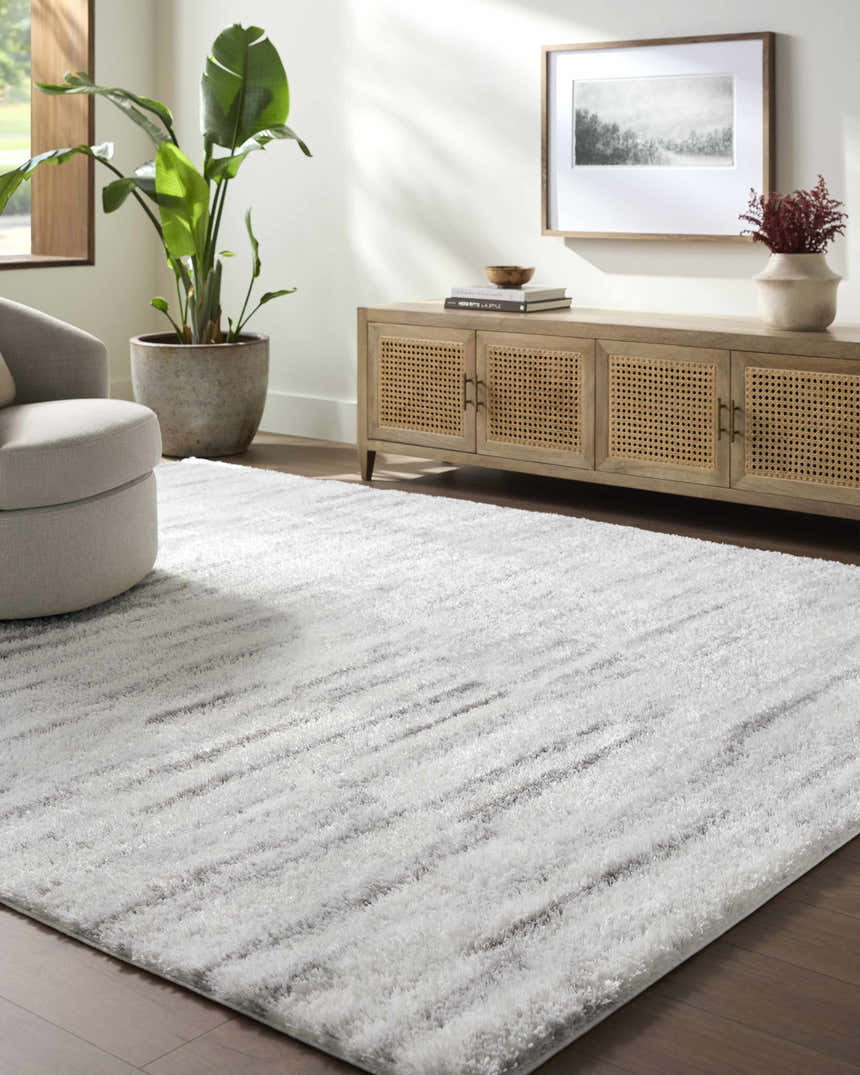 Living room with a gray swivel chair and the Benjen Gray Area Rug. Neutral tones and natural light. Roomscene-Rectangle