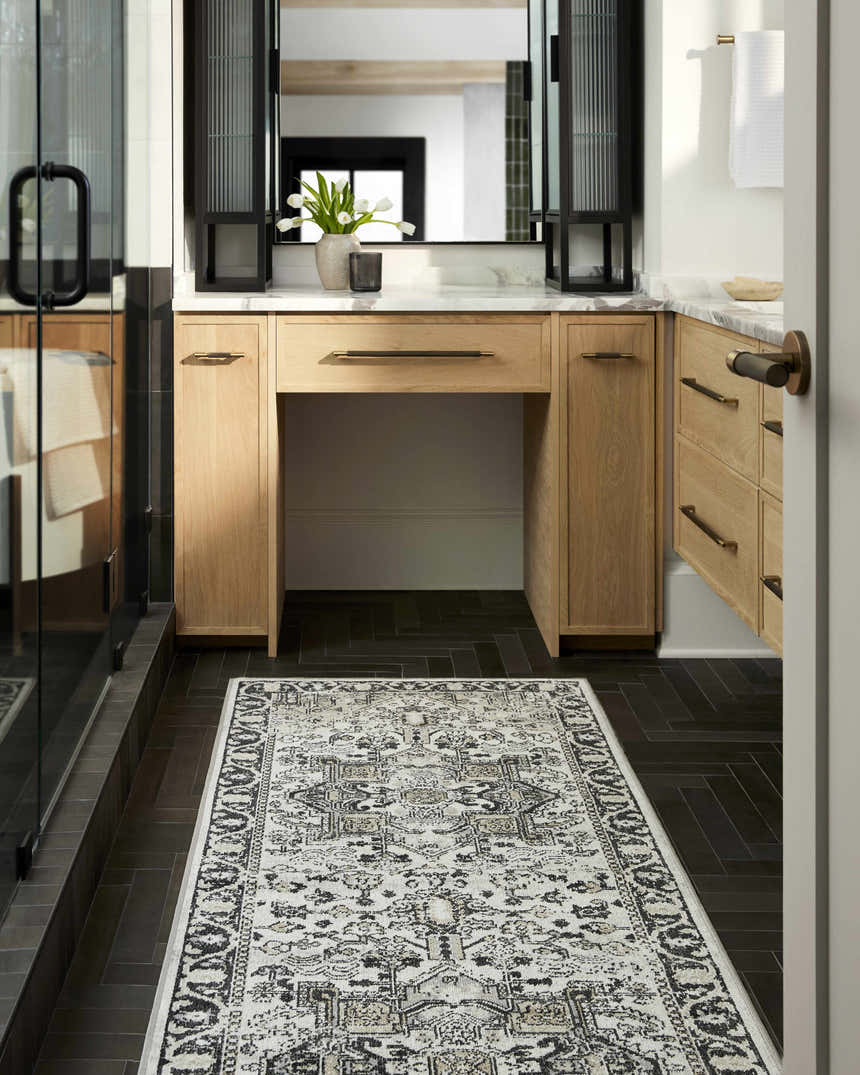 Bathroom scene with a black herringbone floor and a Cabacungan Washable Area Rug in black, gray, and beige. Roomscene-Runner