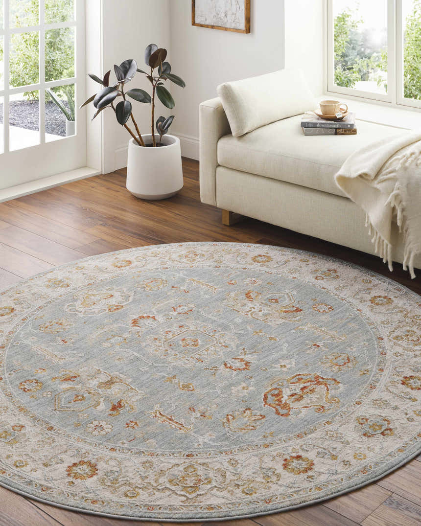 Bright living room with a round Camrose rug in light blue, beige, and brick red tones. Roomscene-Round