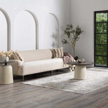 Living room scene with a Cara Flat Pile Washable Rug, beige sofa, round tables, and natural light from a black-framed window. Roomscene-Rectangle