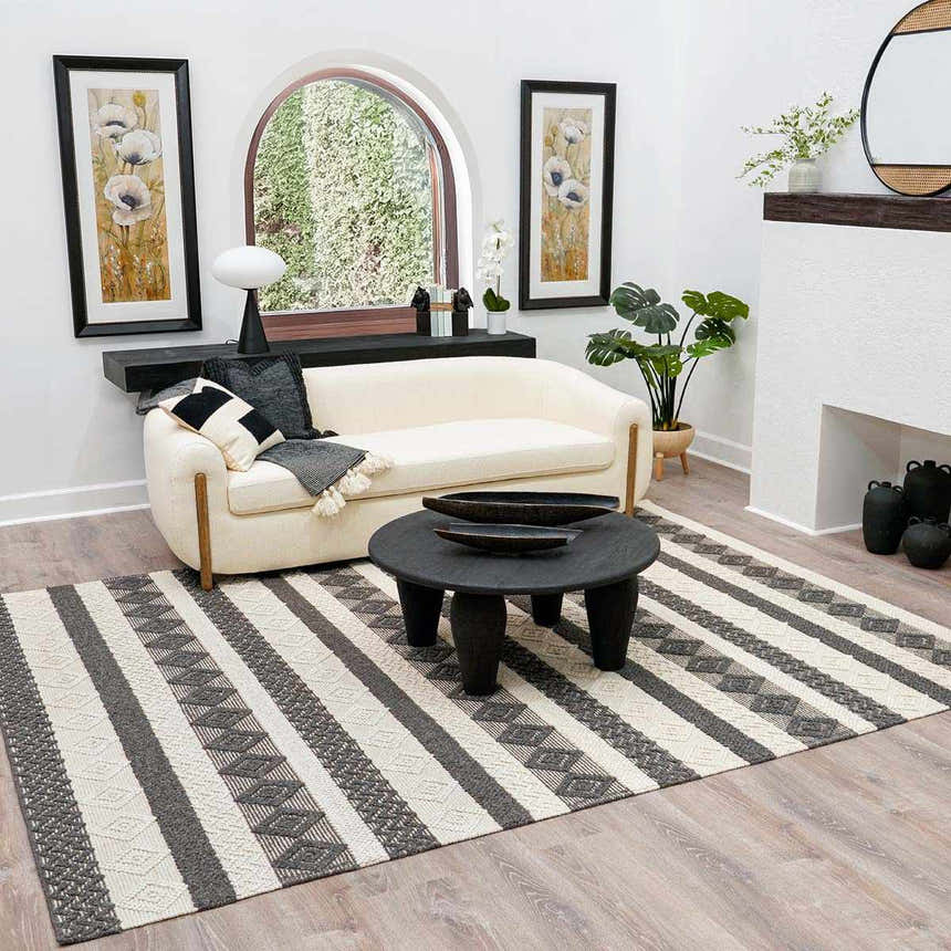 Living room scene with a black round coffee table on the striped Whittington Black&White Wool Rug. Cream sofa and modern decor. Roomscene-Rectangle