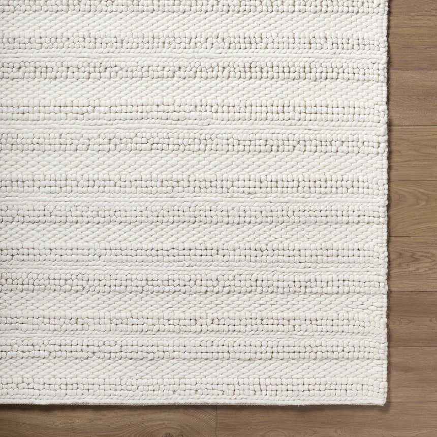 Close up of the hand woven, white, wool Coskun Area Rug showing the textured, farmhouse design. Corner
