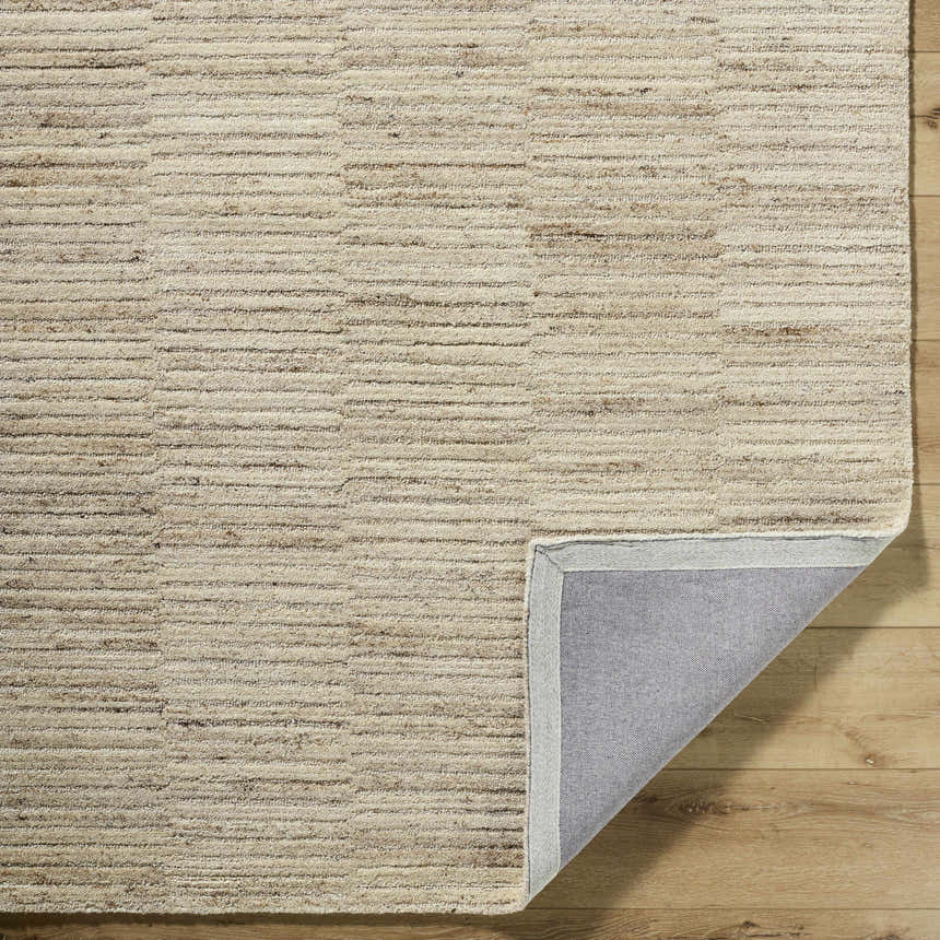 Close-up of the hand-tufted Andred Tan Area Rug. Beige and tan wool rug with a subtle horizontal striped pattern. Fold