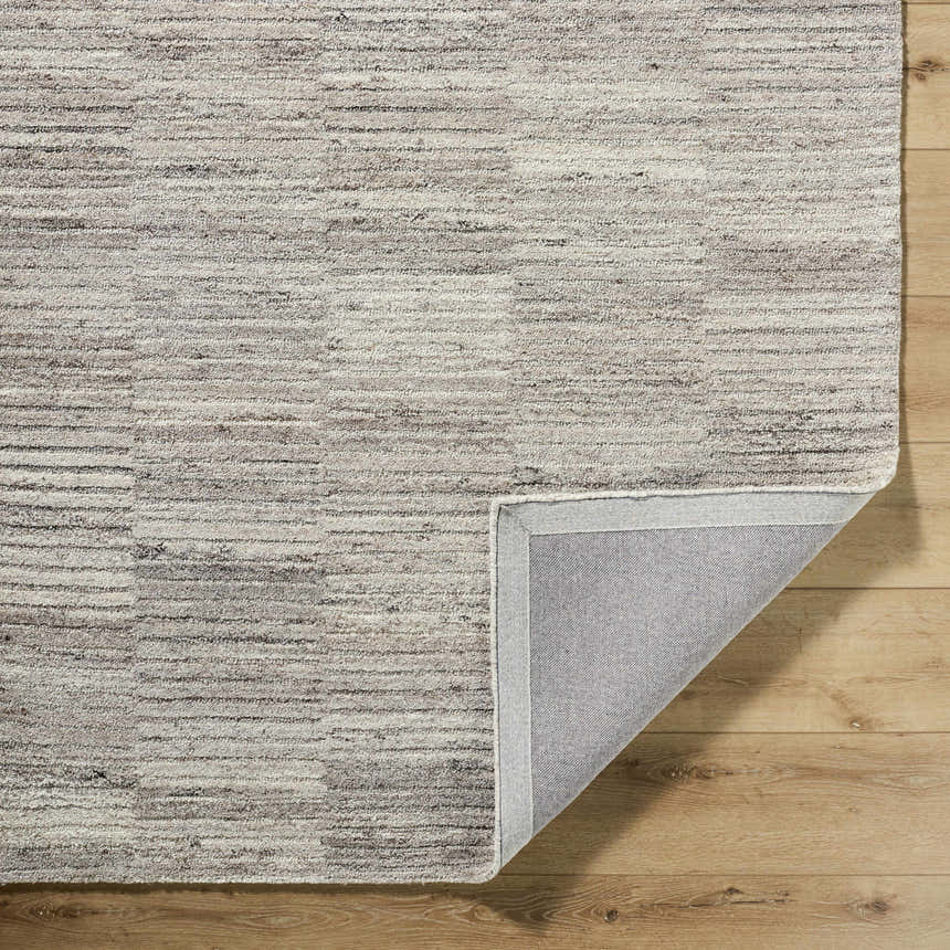 Close-up of the hand-tufted Andred Taupe Area Rug showing its beige, cream, and tan horizontal stripe design and wool texture. Fold