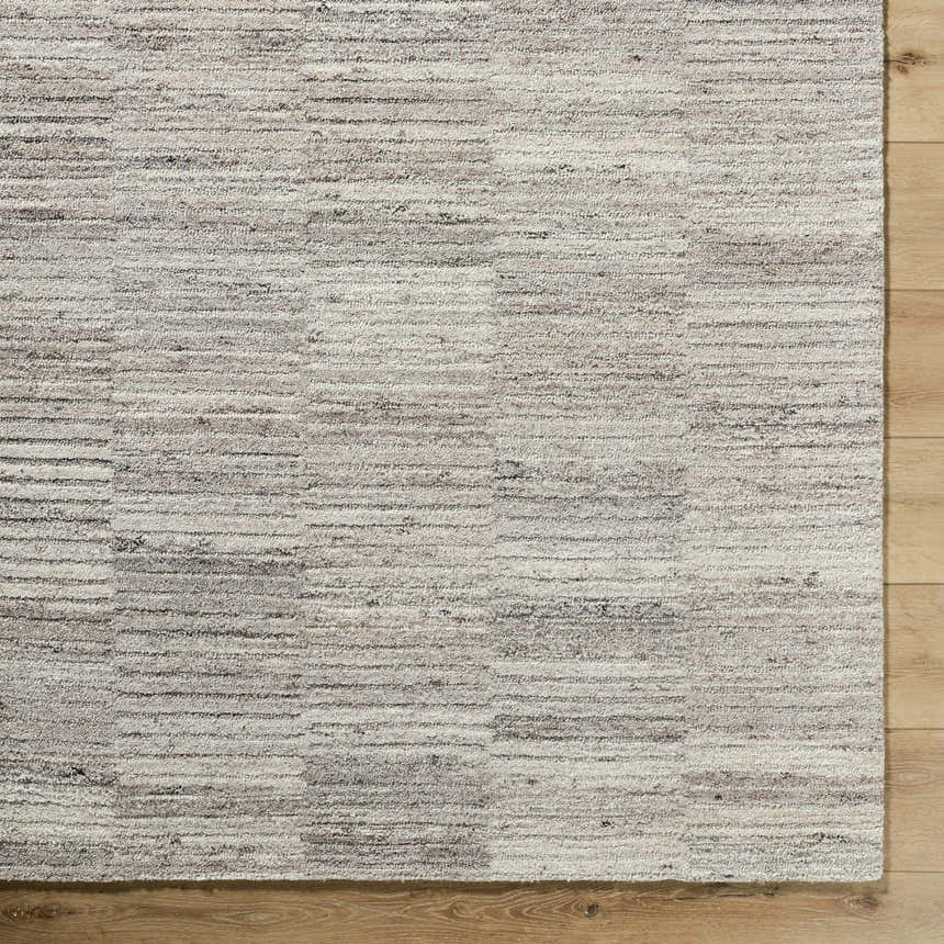 Close-up of the hand-tufted Andred Taupe Area Rug. Beige, cream, and taupe wool rug with subtle horizontal stripes. Corner