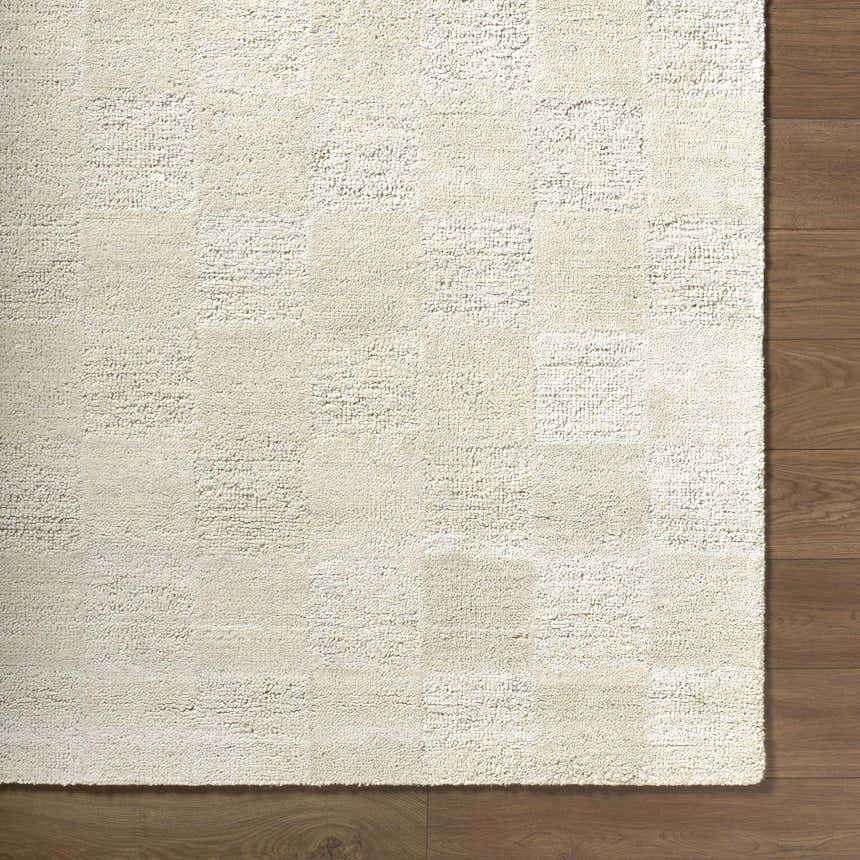 Close up of the hand tufted Chasya Ivory Area Rug showing its subtle square pattern and wool texture. Corner