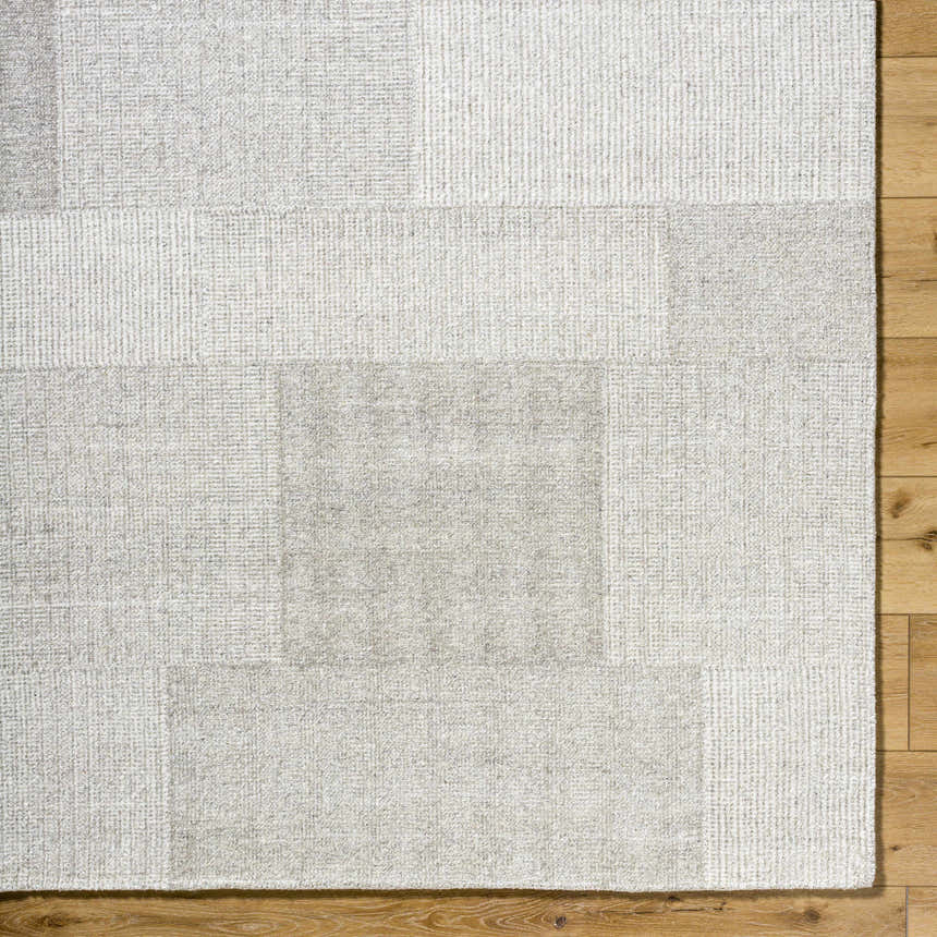 Close-up of the Camila Beige Area Rug showing its subtle geometric pattern and wool texture on a wood floor. Corner