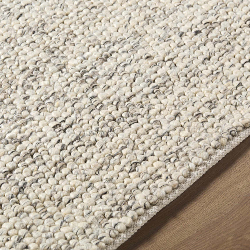 Close-up of the hand woven Clayne Beige & Charcoal Premium Wool Area Rug, showing its textured, looped wool design. Texture