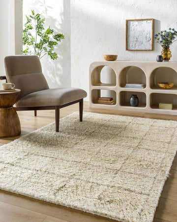 Bright living room with a neutral chair and the Alodie Grid Wool Rug in pearl and light wood tones. Roomscene-Rectangle