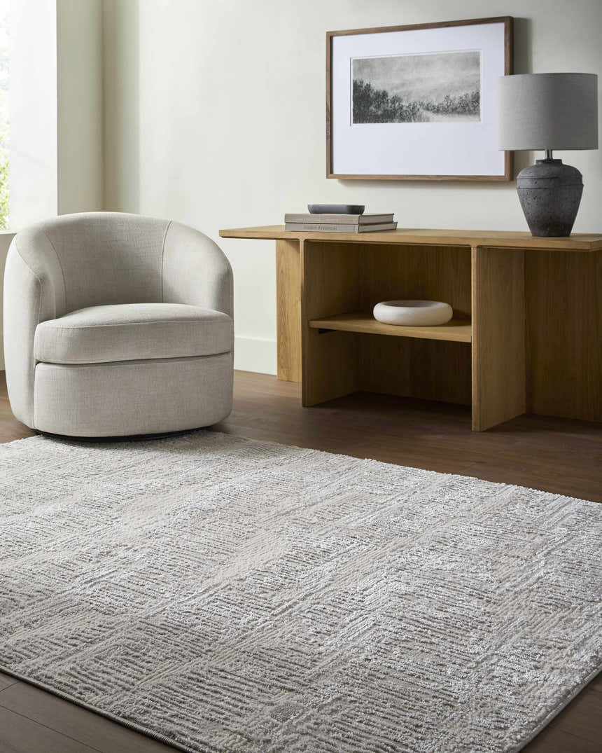 Living room scene with a cream swivel chair and the light gray Annisa Area Rug. Roomscene-Rectangle