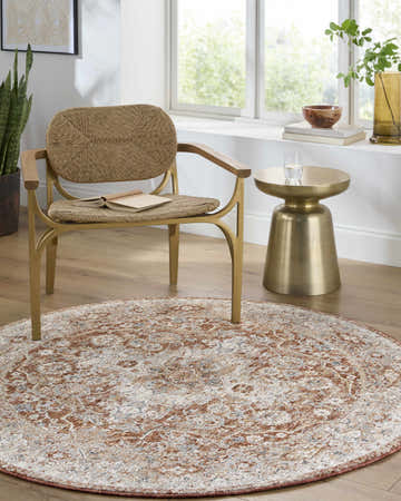 Sunlit room with round Chione Beige Area Rug, woven chair, and gold accent table. Farmhouse style. Roomscene-Round