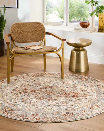 Entryway with a round Chione Slate Blue Area Rug, woven chair, and gold side table. Roomscene-Round