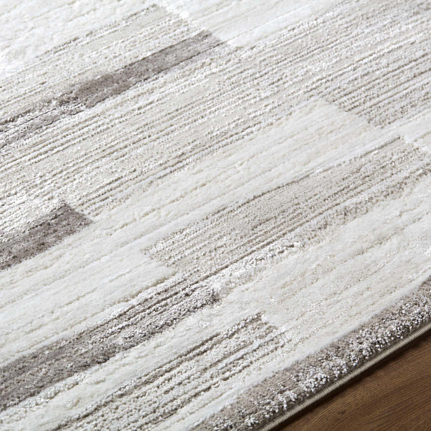 Close-up of the Ananya Area Rug. Ivory, light brown, and gray stripes create a contemporary pattern. Soft polyester texture. Texture