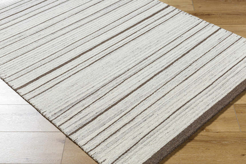 Close up of the Cliona Area Rug showing its taupe and ivory striped pattern and wool texture. Corner