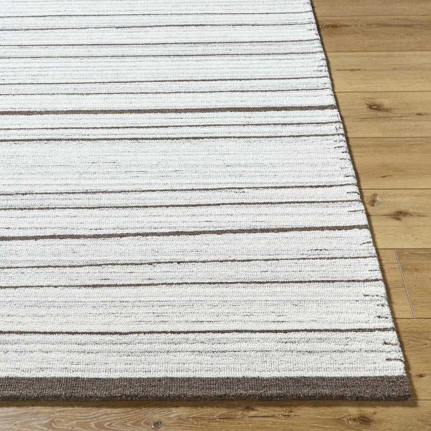 Close up of the hand-tufted Cliona Area Rug. Ivory rug with charcoal and taupe stripes on hardwood floor. Front