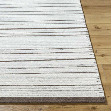 Close up of the hand-tufted Cliona Area Rug. Ivory rug with charcoal and taupe stripes on hardwood floor. Front