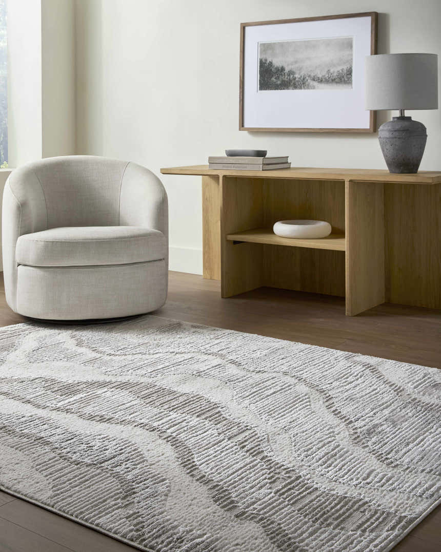 Contemporary living room with a cream chair and the gray and ivory Aniela Area Rug. Roomscene-Rectangle