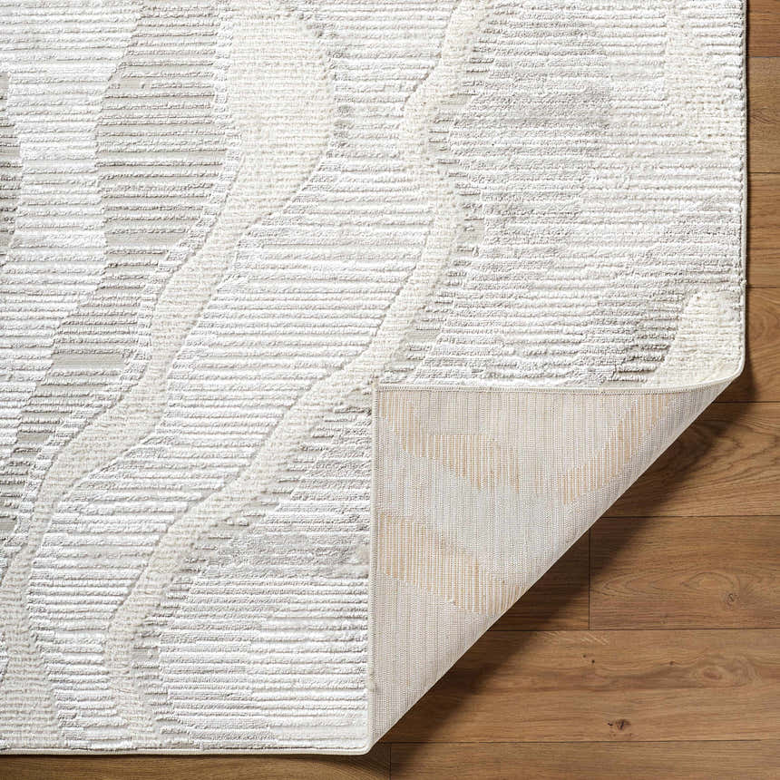Close-up of the Aniela Area Rug showing its cream, ivory, and gray geometric pattern and textured weave. Fold