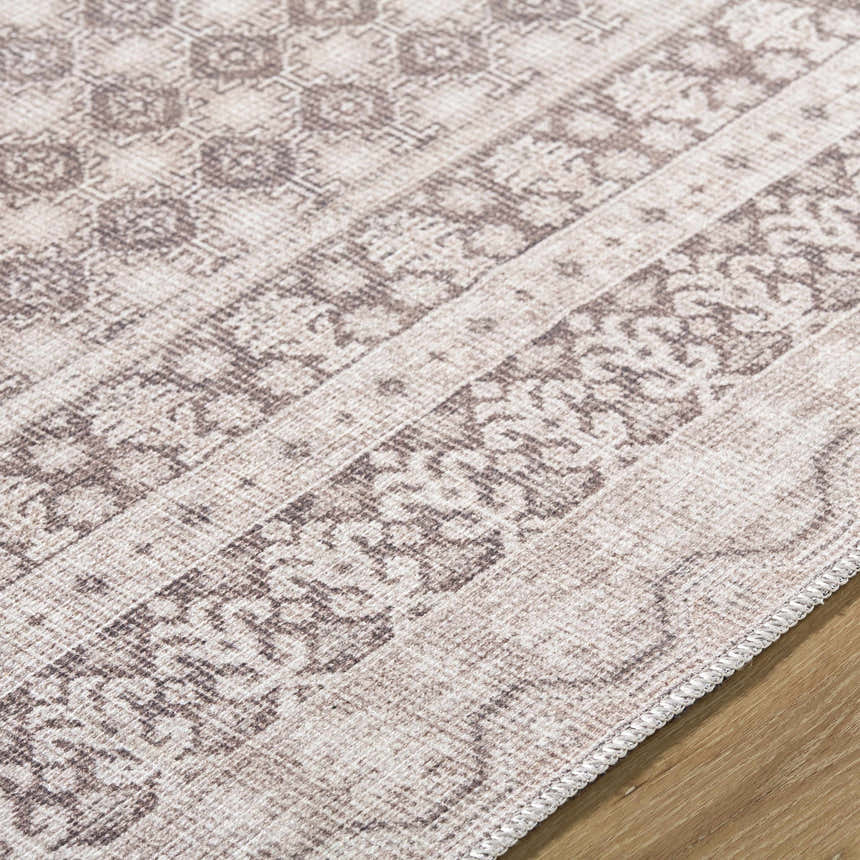 Close-up of the Rainier Light Brown Washable Rug showing its traditional, light brown and cream pattern and machine woven texture. Texture